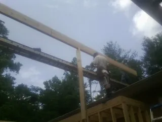 Carpenter setting a ridge beam over a new addition frame — Ice Dam Removal by Roofing Brothers in Steens