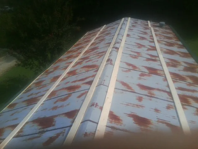 Rusted metal roof panels with new wood purlins before replacement — Storm Damage Roof Repair in Steens by Roofing Brothers